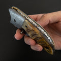 Canivete modelo artesanal com lâmina de aço damasco e dorso ornamentado com trabalho em lima.