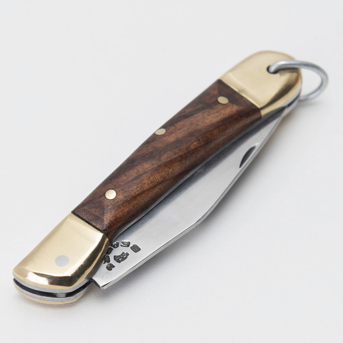 Canivete clássico com lâmina em aço inox 420 e cabo com talas de madeira nobre.