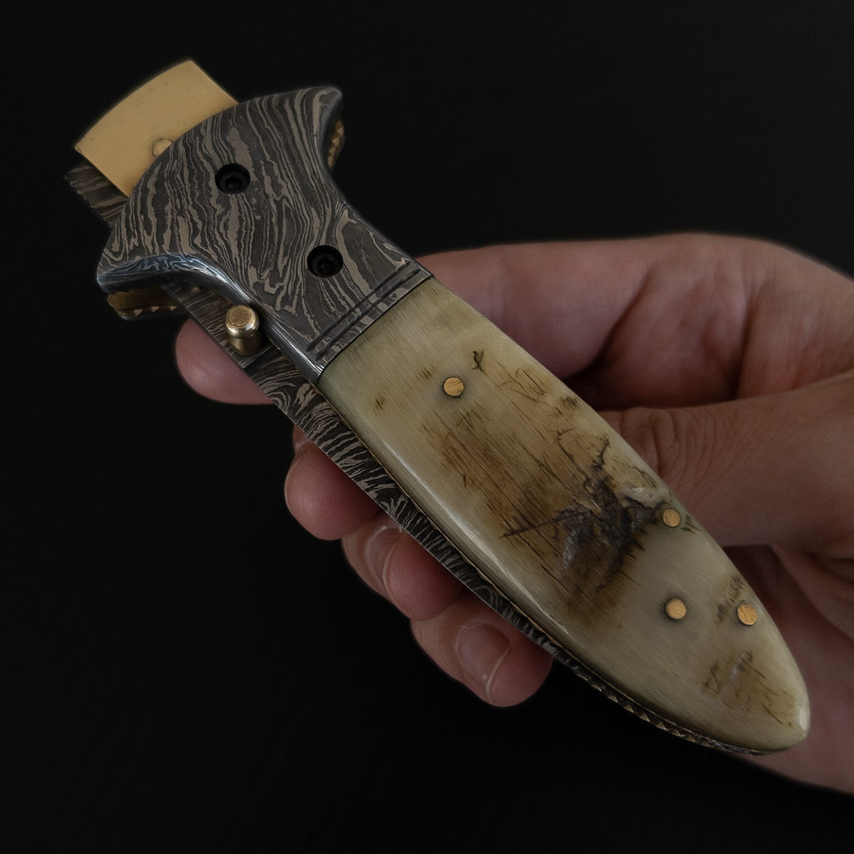 Canivete artesanal com lâmina de aço damasco e cabo com chifre.